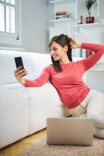Joven Mujer Sonriente Atractiva Sentada Suelo Casa Tomando Selfie Relajándose — Foto de Stock