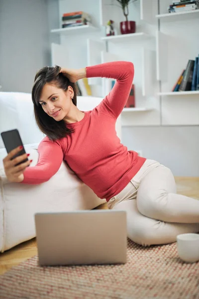 Joven Mujer Sonriente Atractiva Sentada Suelo Casa Tomando Selfie Relajándose — Foto de Stock
