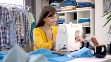 Stüdyosunda oturup güzel bir gece elbisesi dikmeye odaklanmış beyaz bir moda tasarımcısı..