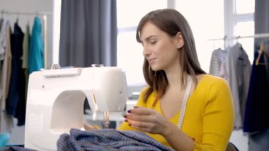 Stüdyosunda oturup güzel bir gece elbisesi dikmeye odaklanmış beyaz bir moda tasarımcısı..