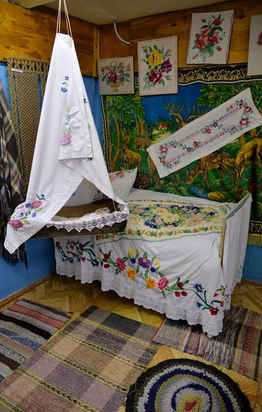 ภายในห้องนอนที่มีเตียงและเปลเก่าตกแต่งด้วย embroideries ในสไตล์รัสเซีย — ภาพถ่ายสต็อก