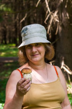 Yaşlı kadın ormanda cep, bozuk para, porcino veya porcini (Boletus edulis) taşır