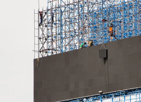 Grupo de trabajadores están escalando postes para instalar carteles led — Foto de Stock