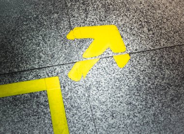 Sarı ok işareti mermer zemin üzerinde gösterir