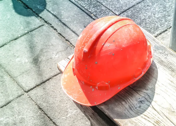 İnşaat sahasında beton yol kenarında duran kırmızı kask — Stok fotoğraf