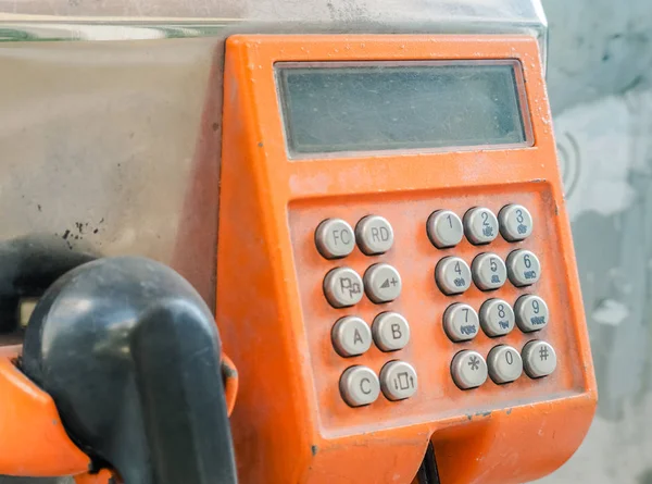 Vecchio numero di pulsanti sul telefono pubblico arancione, messa a fuoco selettiva e immagine ravvicinata — Foto Stock