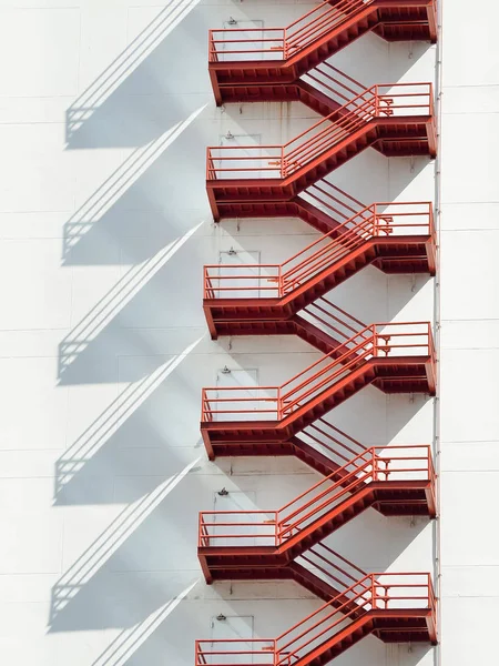 Escadas de fuga de fogo vermelho no edifício branco — Fotografia de Stock