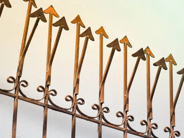 Roestige metalen hek met scherpe pijlen — Stockfoto