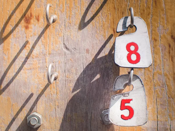 Τους αριθμούς 8 και 5 στις ετικέτες που κρέμονται σε ένα παλιό ξύλινο — Φωτογραφία Αρχείου