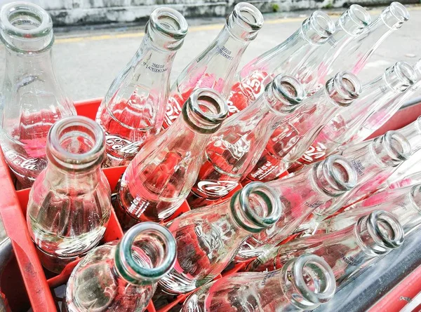 Prullenbak leegmaken flessen Cola in rode plastic doos — Stockfoto