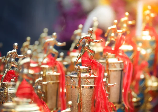 Premios trofeo copa atletas con una cinta roja . — Foto de Stock