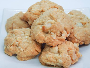 Beyaz arka planda Macadamia kurabiyeleri var. Macadamia fındık kurabiyesi yığını..