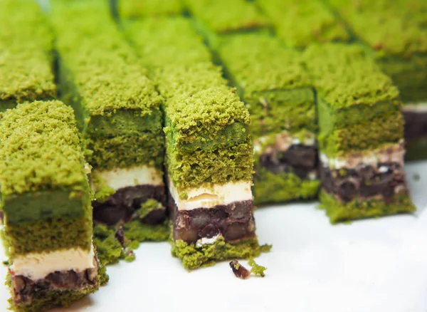 Mini size of green tea cake Arranged on a white plate. Close up of green tea chocolate cake for meal buffet or banquet events.
