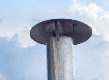 Çatıdaki eski bacalar mavi gökyüzüne karşı. Mutfaktan dumanlar çıkıyor.. 