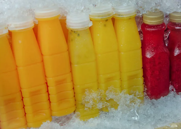 新鲜的胡萝卜汁 橙子和西番莲果 装在现成的冷冻塑料瓶中出售 — 图库照片