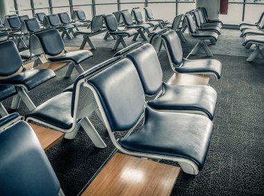 Havaalanı terminalindeki yolcu koltukları boş olan kalkış salonu. Havaalanında bilet kuyruğu var..