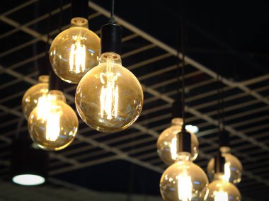 Tavan arkaplanından sarkan parlak ampul. İç nesneler.