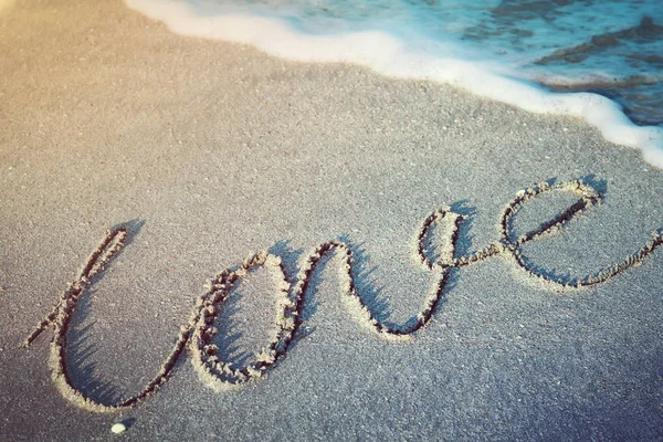 Kumlara, deniz dalgalarına ve plajlara el yazısıyla yazılmış aşk sözcüğü