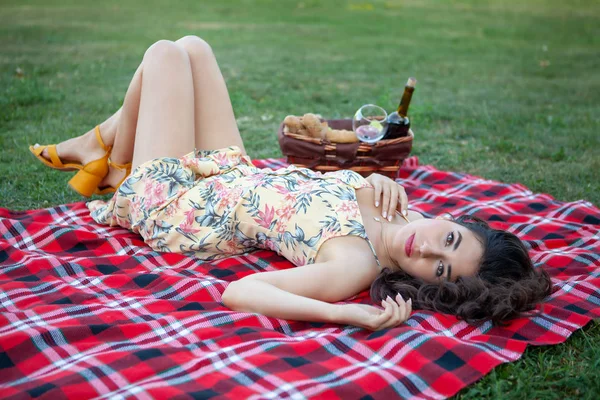 Sexy brunette woman on picnic blanket in the park. — Stock Photo, Image