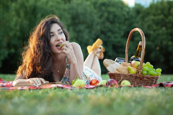 Sexy brunette woman on picnic blanket in the park. — Stock Photo, Image