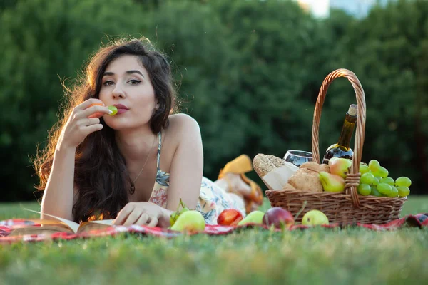 Sexy brunetka žena na piknik deka v parku. — Stock fotografie