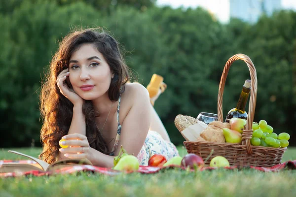 Sexy brunetka žena na piknik deka v parku. — Stock fotografie