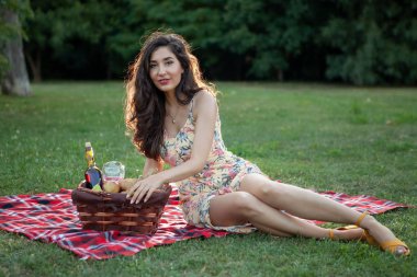 Parkta piknik battaniyesinde seksi esmer kadın..