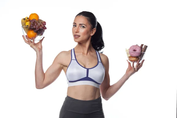 Sexy Brünette Frau Fitnessanzug Die Obst Und Bonbons Isst Studioaufnahmen — Stockfoto