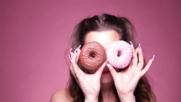 Joven Mujer Sexy Comiendo Donas Estudio Plano Sobre Fondo Rosa — Vídeo de stock