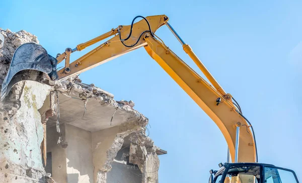 Demolition of an old house with excavator