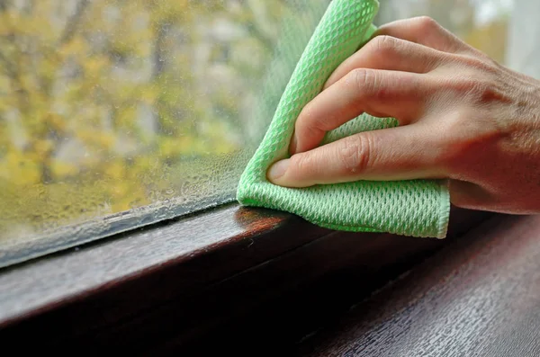 Schoonmaken van de condensatie van het water op venster vrouw — Stockfoto