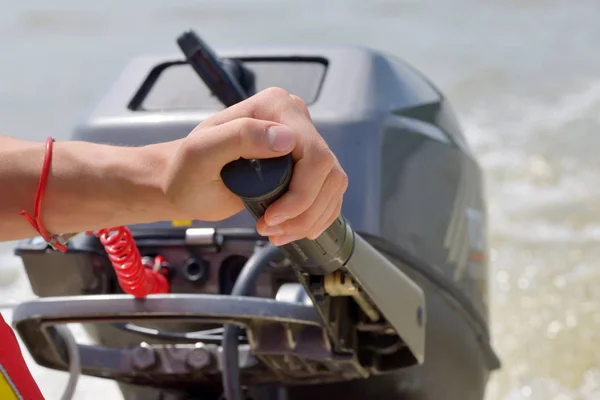 Fisherman hand and boat engine — Stock Photo, Image