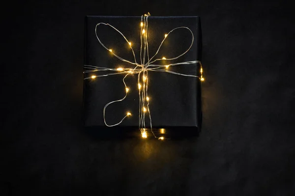 Caja de regalo envuelta con luces de cuerda —  Fotos de Stock