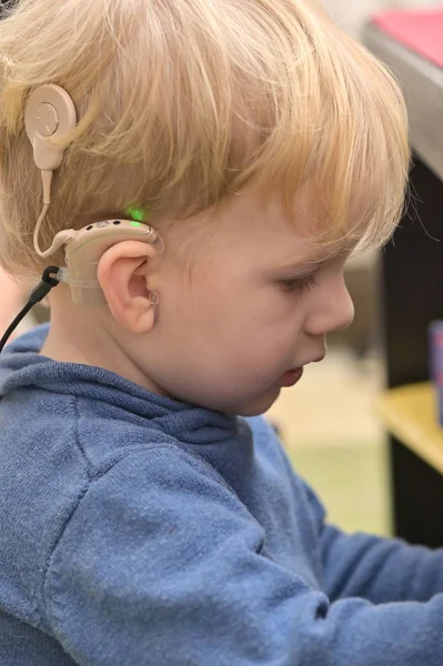Pojke med hörapparat och Cochlear implantat Royaltyfria Stockbilder