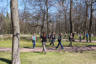 Parkta ağaçların arasında gençler.