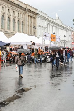Tatilde şemsiyeler altında insanlar.