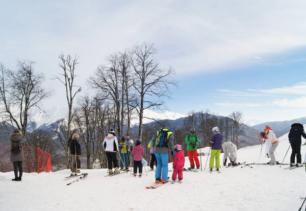 Group of adults with children on skis.