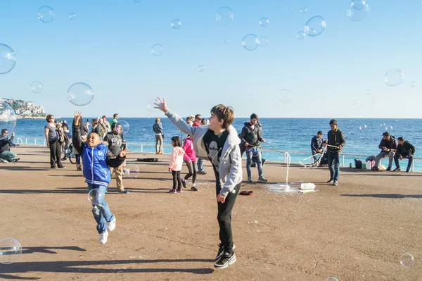 Los niños en un salto atrapan burbujas de jabón . — Foto de Stock