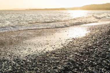 Sahilde bronz günbatımı.