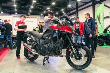 Bir adam bir motosiklet üzerinde oturuyor.