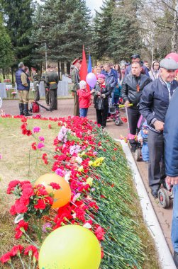 İnsanlar çiçekler ile mezar Hill.