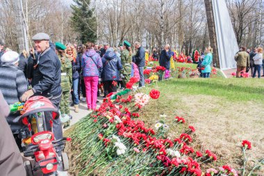 İnsanlar ve toplu mezarlar üzerinde çiçekler.