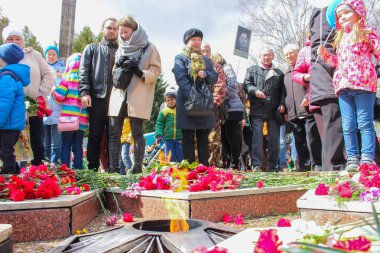 İnsanlar ve Eternal Flame etrafında çiçekler.