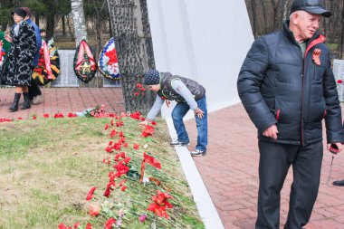 Bir genç bir çiçek mezar koyar.