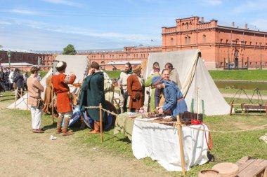 İnsanlar Tadiç giysili.