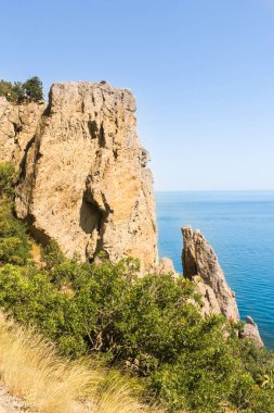 Denize dik kayalıklarla.