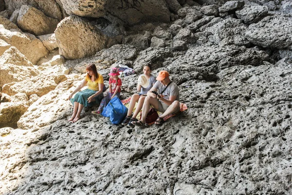 Un grupo de personas descansando sobre una roca . — Foto de Stock