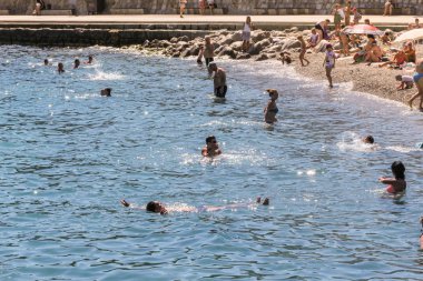 İnsanlar sahilde yüzüyor.