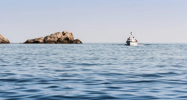 Un barco en el mar junto a la piedra . —  Fotos de Stock