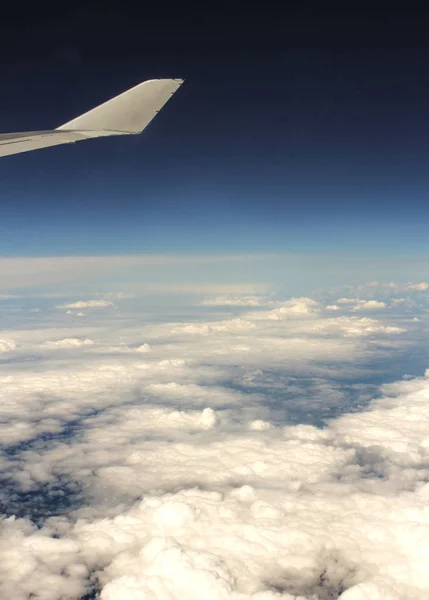 Een laag van wolken onder de vleugels van het vliegtuig. — Stockfoto